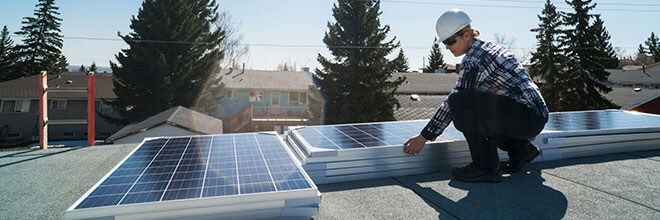Man attaching new solar panels on house rooftop